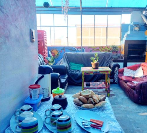 ein Wohnzimmer mit einem Tisch mit Teller und Schüsseln in der Unterkunft Backpacker Oruro in Oruro