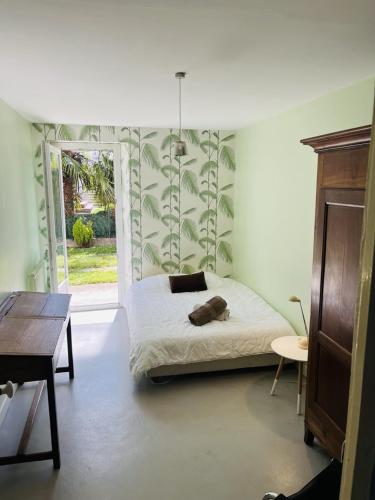 une chambre avec un lit et une grande fenêtre dans l'établissement Vallons Bayonne - Aritxague - Maison - piscine, à Bayonne