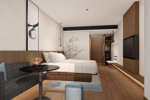 Schlafzimmer mit einem Bett, einem Tisch und einem TV in der Unterkunft Fairfield by Marriott Shenzhen Bao'an in Shenzhen