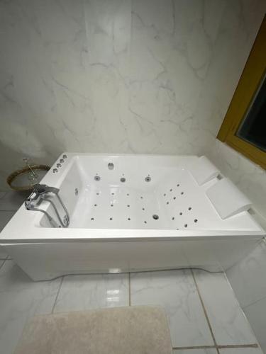 a white bath tub with a sink in a bathroom at Gold Spa in Roubaix