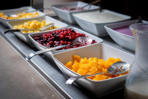 a table topped with trays of different types of food at Mövenpick Hotel Geneva in Geneva