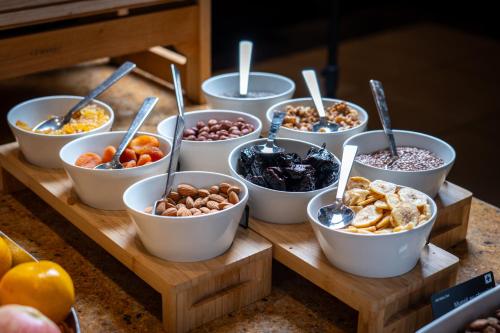 a bunch of bowls of food on a table at Mövenpick Hotel Geneva in Geneva