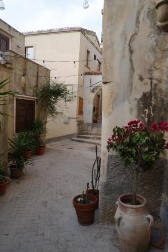 an alley with potted plants on the side of a building at Casa Catalé in Modica