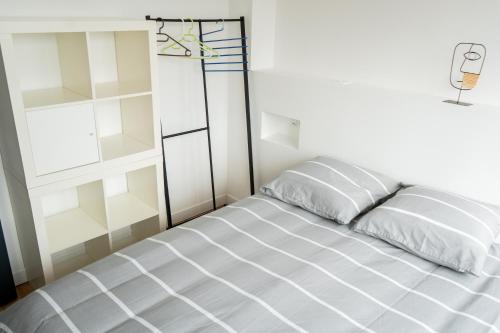 ein Bett in einem weißen Zimmer mit einem Fenster in der Unterkunft Maison charmante et spacieuse-terrasse près du centre ville in Amiens