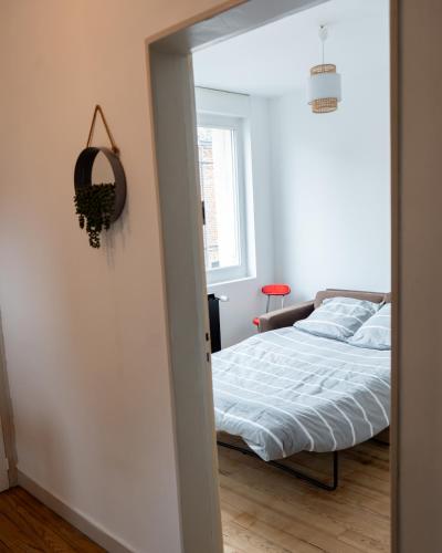 une chambre avec un lit, une fenêtre et un miroir dans l'établissement Maison cosy tout équipée à 15mn à pied de la ville, à Amiens