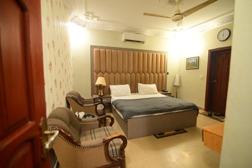 a bedroom with a bed and a chair in it at SEAVIEW COTTAGE in Karachi