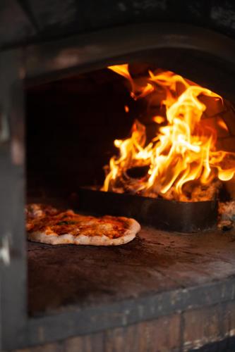 two pizzas are cooking in a brick oven at Hoot in Abergele