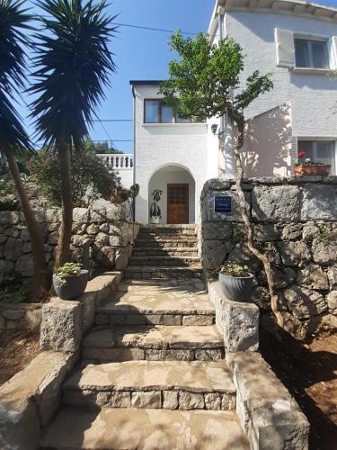 una escalera de piedra que conduce a una casa con una palmera en Apartment Nadine Mljet, en Okuklje