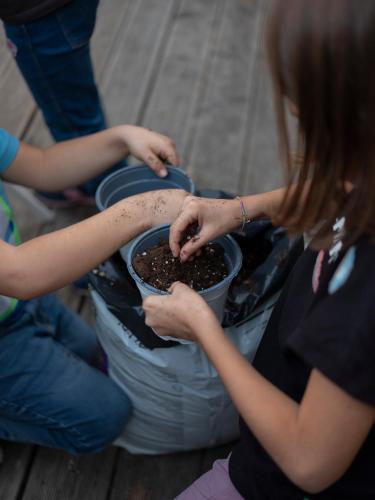 two women are planting seeds in a pot at Imago Plus Hotel in Bari
