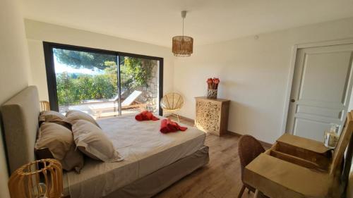 une chambre avec un lit et une grande fenêtre dans l'établissement Proche porticcio, Coup de cœur asuré,Appartement de standing, rez de villa 6 couchages, climatisé à 150m de la plage, terrains de tennis, à Grosseto-Prugna