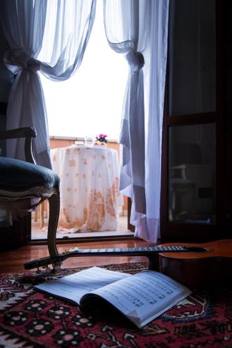 an open book on a table with a chair and a window at Al Parco Storga B&b in Treviso
