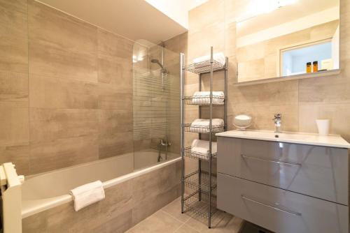 une salle de bain avec un lavabo, une baignoire et une douche dans l'établissement A083 - Modern & Bright apt - Cannes center, à Cannes