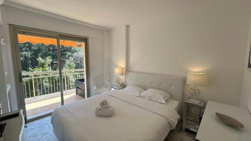 - une chambre avec un grand lit blanc et une grande fenêtre dans l'établissement A083 - Modern & Bright apt - Cannes center, à Cannes