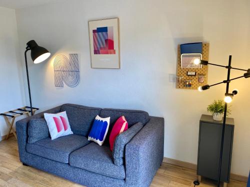 a living room with a blue couch with pillows at Ma place au sud Aix Parking in Aix-en-Provence