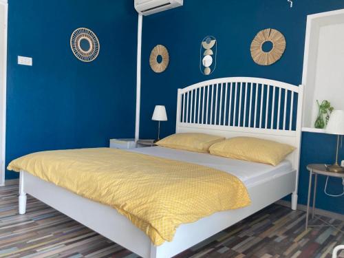 um quarto com uma cama com uma parede azul em Guest House Busurelo em Polace