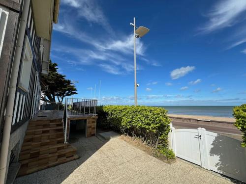 a house with a street light next to the ocean at Demeure rénovée front de mer in Courseulles-sur-Mer