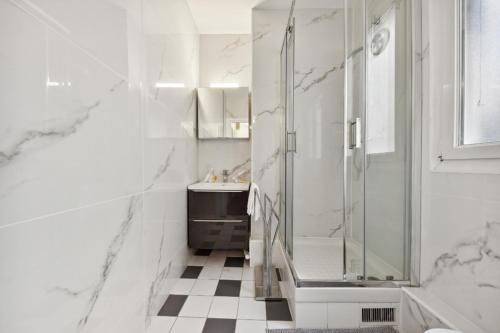 une salle de bain blanche avec une douche et un lavabo dans l'établissement 516 Suite Champion - Superb apartment in Paris, à Paris
