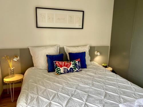 a bed with pillows on it in a bedroom at Ma place au sud Aix Parking in Aix-en-Provence