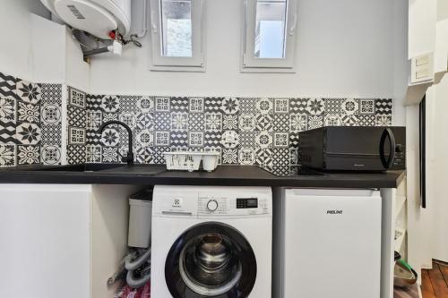 une cuisine avec une machine à laver sous un comptoir dans l'établissement 516 Suite Champion - Superb apartment in Paris, à Paris