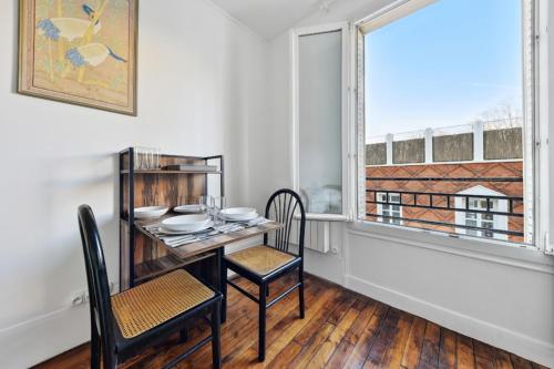 une salle à manger avec une table et des chaises et une fenêtre dans l'établissement 516 Suite Champion - Superb apartment in Paris, à Paris