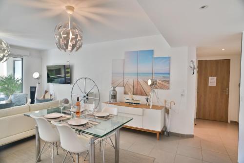 une salle à manger et une cuisine avec une table et des chaises dans l'établissement Appartement de rêve avec terrasse et garage, à Cannes