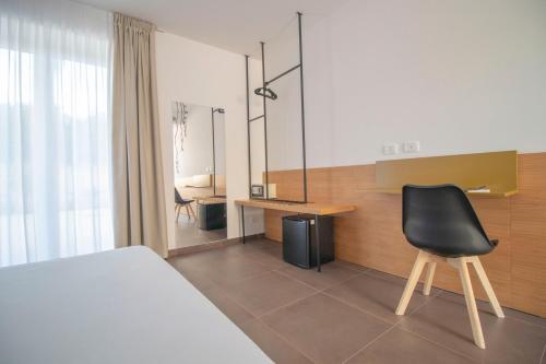 a bedroom with a bed and a desk and a chair at Hotel Arte Mare in San Vito lo Capo