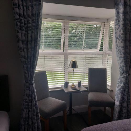 a room with two chairs and a table in front of a window at Farmleigh House, in Donegal