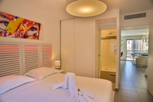 - une chambre avec un lit blanc et un miroir dans l'établissement Appartement de rêve avec terrasse et garage, à Cannes