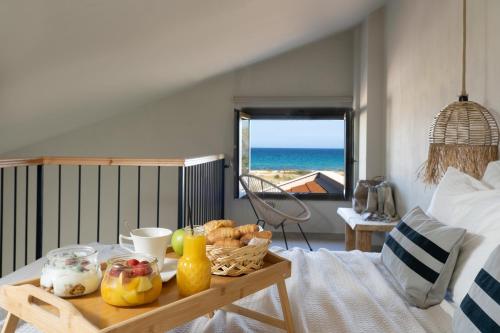 a table with a tray of food on top of a bed at Amo Golden Suites in Chrysi Ammoudia