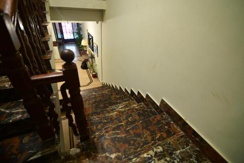 a hallway with a stone floor and a white wall at SEAVIEW COTTAGE in Karachi