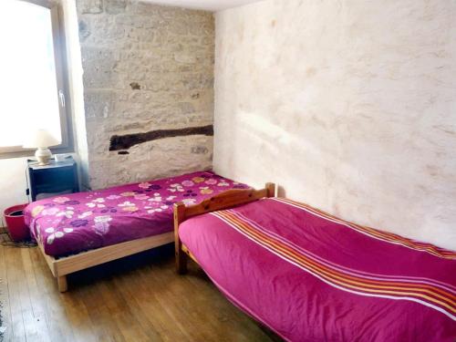 1 Schlafzimmer mit 2 Betten und lila Bettwäsche in der Unterkunft Maison de 3 chambres avec jardin clos et wifi a Lalbenque in Lalbenque