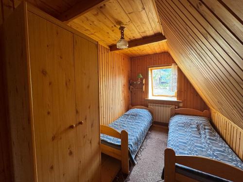 une chambre avec deux lits dans une cabane en bois dans l'établissement Pokoje Regle 30, à Zakopane