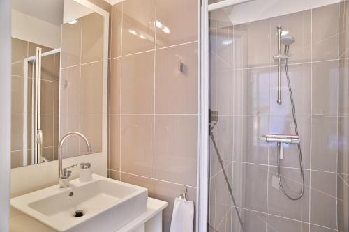 La salle de bains est pourvue d'un lavabo et d'une douche. dans l'établissement Appartement de rêve avec terrasse et garage, à Cannes