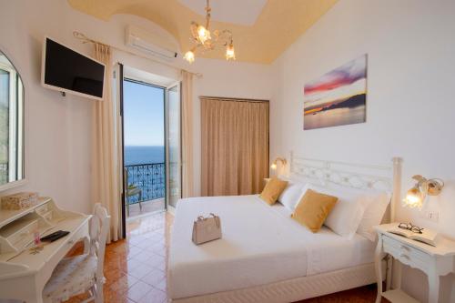 um quarto branco com uma cama e uma varanda em Flatiron app 1 by Sosòre Holiday Homes - Amalfi Coast em Praiano