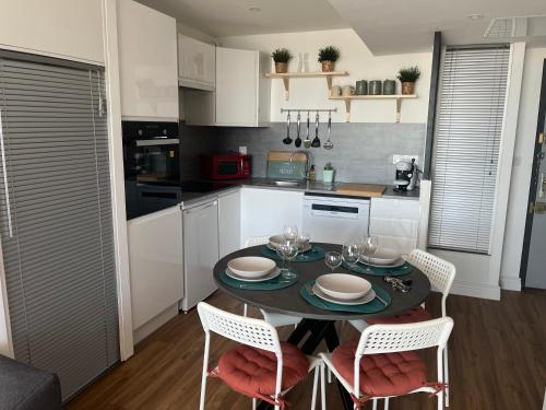 une cuisine avec une table et des chaises dans une pièce dans l'établissement Studio sur le port B, à La Grande Motte