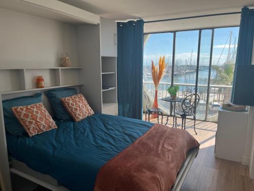 une chambre avec un lit et un balcon avec vue dans l'établissement Studio sur le port B, à La Grande Motte
