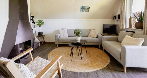 a living room with a couch and a table at Bungalows in het Holt in Gramsbergen