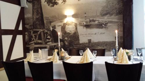 a table with a white table cloth and chairs with candles at Fachwerk-Hotel Eisenbart in Hannoversch Münden