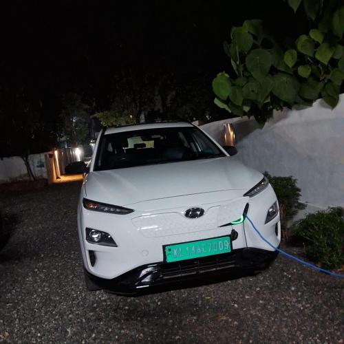 a white car parked next to a wall at Nature Villa Kochi in Alwaye