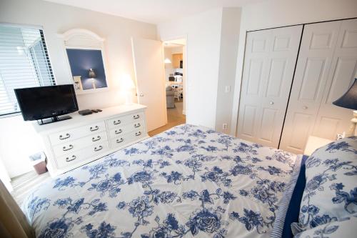 a bedroom with a blue and white bed and a television at The Shores in Williamsburg