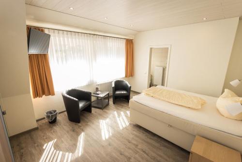 ein Hotelzimmer mit einem Bett, einem Schreibtisch und Stühlen in der Unterkunft Hotel Restaurant Ketterer am Kurgarten in Triberg