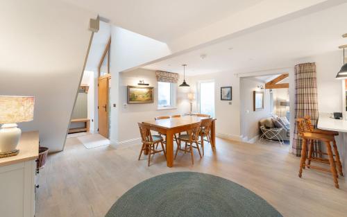 a dining room and living room with a table and chairs at Orchard Mount in Troutbeck