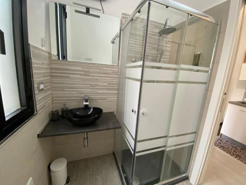 een badkamer met een wastafel en een glazen douche bij Newhouse CRISPI 78 in Bari