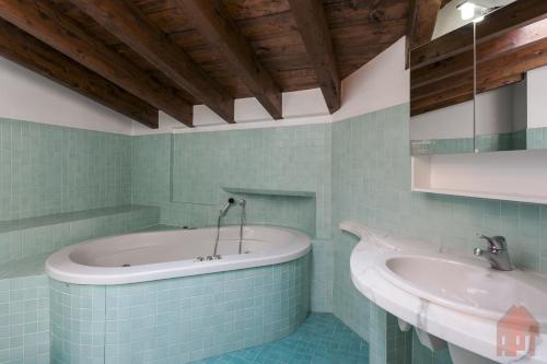 un bagno con 2 lavandini e una vasca di Duplex open space with private courtyard in center a Desenzano del Garda