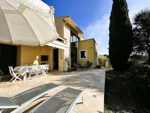 a patio with a table and chairs and a building at L'Estagnol, Maison pour 6 personnes à La Londe-les-Maures in La Londe-les-Maures
