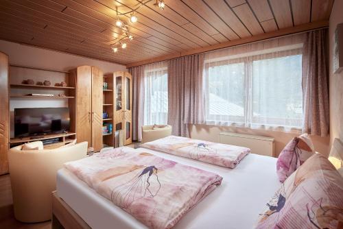 1 dormitorio con 2 camas y ventana grande en Appart Burgwies ink Nationalpark Sommercard, en Stuhlfelden