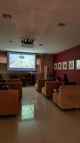 a living room with chairs and a large screen at HDA Hotel & Spa in Termas de Río Hondo