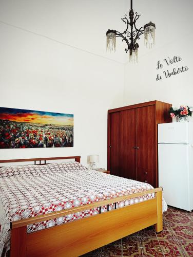 a bedroom with a bed and a painting on the wall at Le volte di Umberto: camera e rilassante terrazzo in Sogliano Cavour