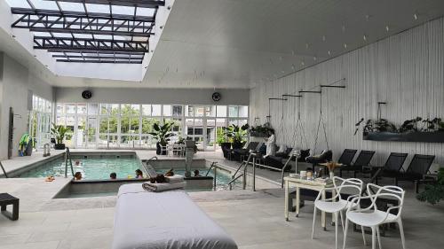 Großes Zimmer mit einem Pool mit Stühlen und einem Tisch. in der Unterkunft HDA Hotel & Spa in Termas de Río Hondo