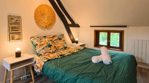 une chambre avec un lit vert avec un animal en peluche dessus dans l'établissement Le Cosy Dampierre, à Troyes
